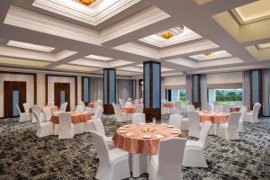 a banquet hall with tables and white chairs at Fortune Park, Hoshiarpur - Member ITC's Hotel Group in Hoshiārpur