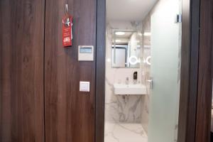 a bathroom with a wooden door and a sink at Hotel & Restaurant Knote in Sindelfingen