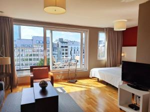 una camera d'albergo con un letto e una grande finestra di MAS Aparthotel EU a Bruxelles