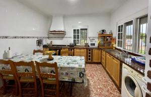 een keuken met een tafel, een wastafel en een fornuis bij Chalet en la playa de Bolonia in Tarifa