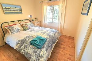 Un dormitorio con una cama con una bolsa verde. en Family Friendly Beach House, en Goolwa South