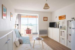 Televízia a/alebo spoločenská miestnosť v ubytovaní Charmant à 600 m des plages proche des commerces LESCLESDENICOLE
