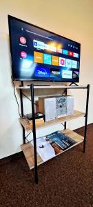 a flat screen tv on a tv stand with a table at Self Check-In Loft in Klaipeda city centre Free Parking in Klaipėda