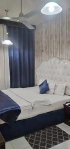 a bedroom with a large white bed with blue pillows at Golden Star Hotel in Dubai
