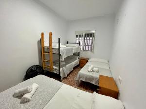 um pequeno quarto com 2 camas e uma janela em Chalet en la playa de Bolonia em Tarifa