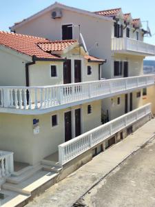 budynek z białymi balkonami i białymi barierkami w obiekcie Apartmani Roko w mieście Okrug Donji