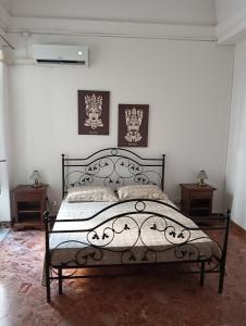 a bedroom with a black bed with two night stands at Arco del vescovo 2 in Acireale