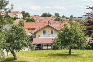 a yellow house with red roofs in a village at Franzl's Ferienwohnungen in Bad Birnbach