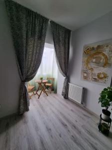 a living room with a table and a window at Green Apartment Old Town in Bucharest