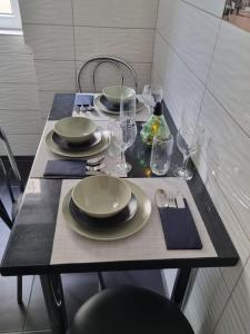 a table with plates and glasses on a table at Green Apartment Old Town in Bucharest