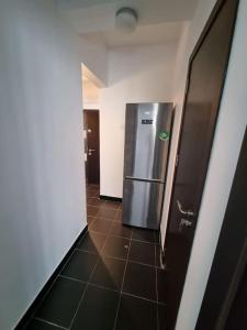 a hallway with a stainless steel refrigerator in a room at Green Apartment Old Town in Bucharest