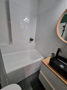 a bathroom with a white tub and a sink at Green Apartment Old Town in Bucharest