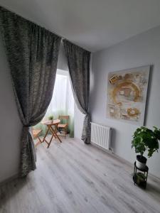 a living room with a table and a window at Green Apartment Old Town in Bucharest