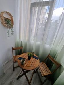a table and two chairs in a room with a window at Green Apartment Old Town in Bucharest