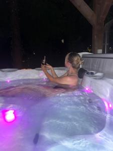 a woman sitting in a hot tub at night at Apartments Strmac in Slunj