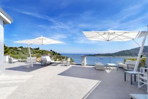 a patio with chairs and umbrellas and the water at Cristallo Park Hotel in Portovenere