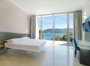 a bedroom with a bed and a large window at Cristallo Park Hotel in Portovenere