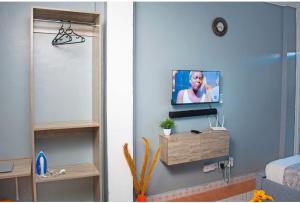 a room with a television on a blue wall at Emap Homes- Silver Studio in Kilifi