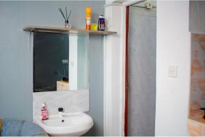 a bathroom with a sink and a mirror at Emap Homes- Silver Studio in Kilifi