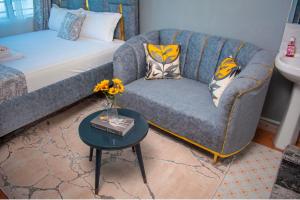 a living room with a couch and a table with flowers at Emap Homes- Silver Studio in Kilifi