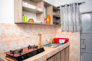 a kitchen with a stove and a sink at Emap Homes- Silver Studio in Kilifi