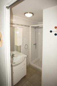 a white bathroom with a sink and a shower at Studio Central in Canet-en-Roussillon