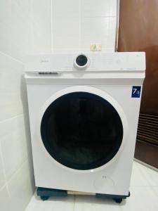 a white washing machine sitting in a room at Stylish comfy studio and workspace in Cebu City