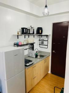 a kitchen with a sink and a refrigerator at Stylish comfy studio and workspace in Cebu City
