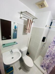 Stylish comfy studio and workspace في مدينة سيبو: حمام به مرحاض أبيض ومغسلة