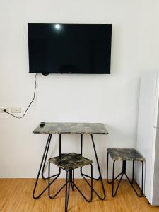 Stylish comfy studio and workspace في مدينة سيبو: طاولة مع كرسيين وتلفزيون على الحائط