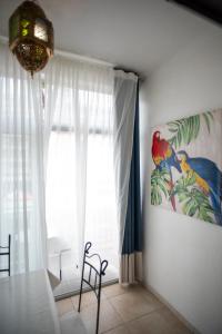 a dining room with a table and a painting of parrots at Studio Central in Canet-en-Roussillon