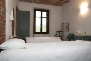 a room with two beds and a window at Agriturismo Il Buonvicino in Cassine