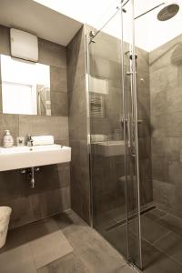 uma casa de banho com um chuveiro e um lavatório. em Raimond Apartment em Viena