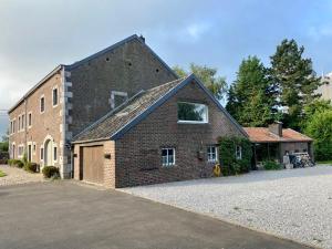 a large brick house with a garage and a driveway at Gite Pays de Herve - Emeraude in Battice