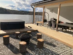 ein Dock mit Grill und Holzscheiten auf einem See in der Unterkunft Comfortable villa with a hot tub 
