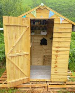 a wooden out house with a wooden door at Glyndwr Bell Tent in Builth Wells