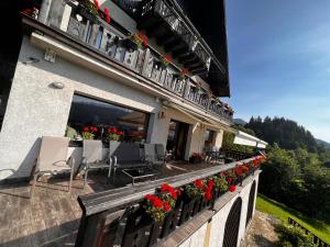 a balcony of a building with red flowers on it at Bucovina Lodge Pension in Vama
