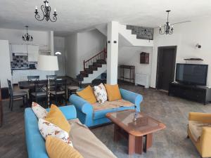 sala de estar con sofás azules y TV en Sunset Villa Montenegro, en Radovanići