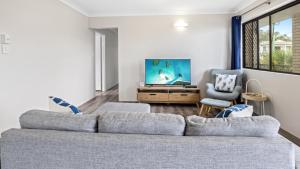 a living room with a couch and a tv at Beachside Unit In The Center Of Town in Woorim +7 photos