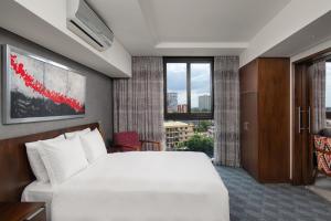 um quarto de hotel com uma cama branca e uma janela em Crowne Plaza - Dar Es Salaam, an IHG Hotel em Dar es Salaam