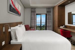 um quarto de hotel com uma cama, uma secretária e uma janela em Crowne Plaza - Dar Es Salaam, an IHG Hotel em Dar es Salaam