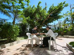Ein Mann und eine Frau sitzen an einem Tisch in der Unterkunft Route Inn Grantia Ishigaki in Ishigaki-jima