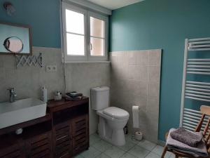 a bathroom with a toilet and a sink and a window at Perfect Gites In Normandy 