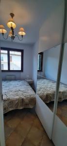錫羅洛的住宿－Casa Mia Sirolo，一间卧室配有两张床和镜子