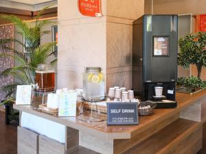 a store counter with a shelf with a coffee maker at Route Inn Grantia Ishigaki in Ishigaki Island