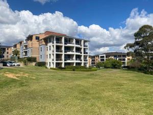 a large apartment building with a large grass field at Apartment in Chiswick with Pool, sauna & Gym in Sydney