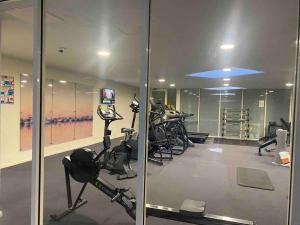 a gym with treadmills and exercise bikes in a room at Apartment in Chiswick with Pool, sauna & Gym in Sydney