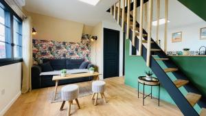 a living room with a couch and a staircase at Appartement La Cabane de la Baie. in Étaples