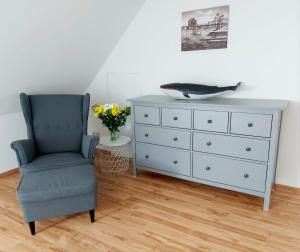 a bedroom with a dresser and a chair with a bowl on it at Hochwertige Ferienwohnung direkt am Hafen mit Balkon in Ostseebad Karlshagen