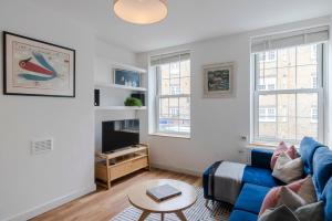 a living room with a blue couch and a table at Central Euston One Bedroom Home in London